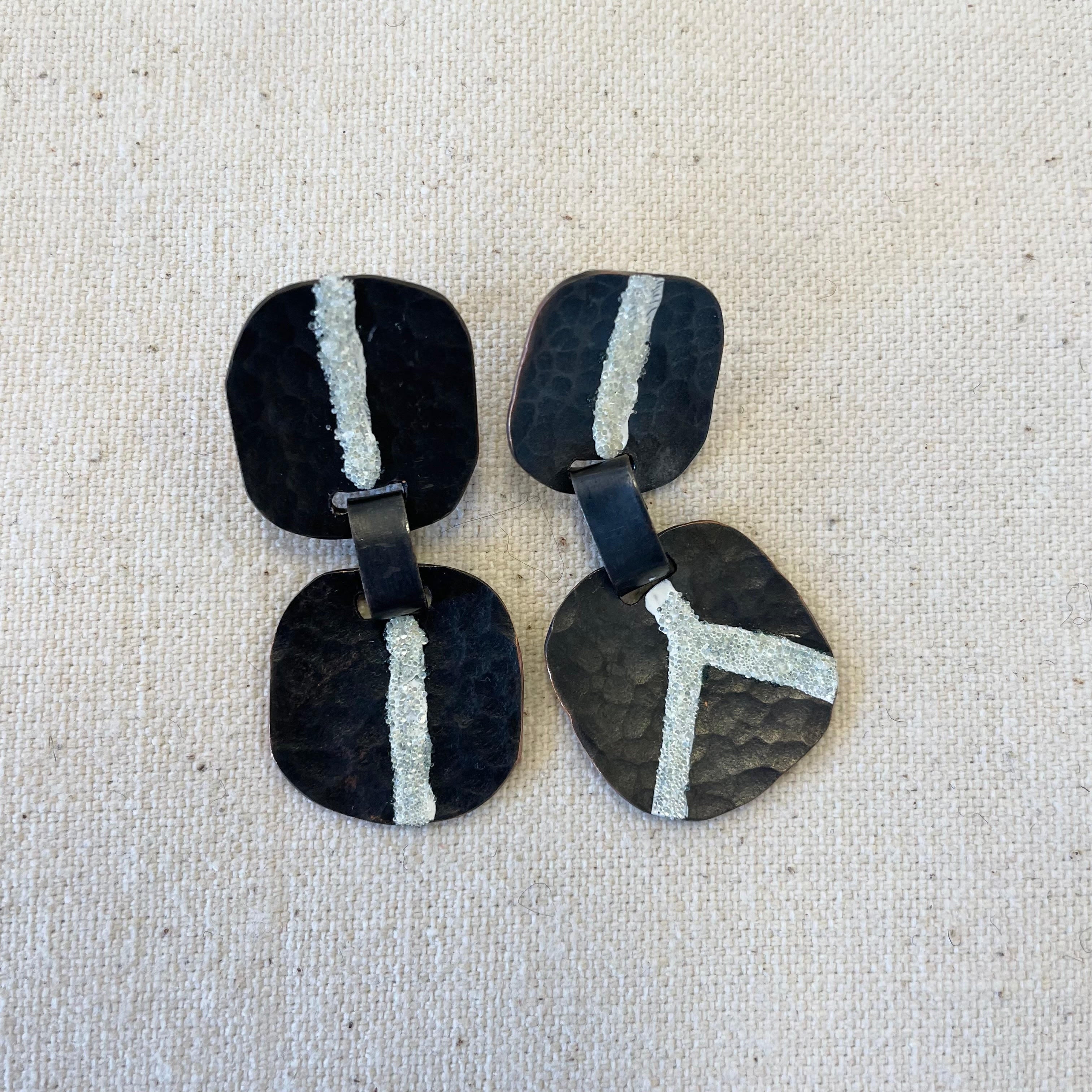 Earrings by Hilary Johnstone. Silver with reflective road marking beads in lines.