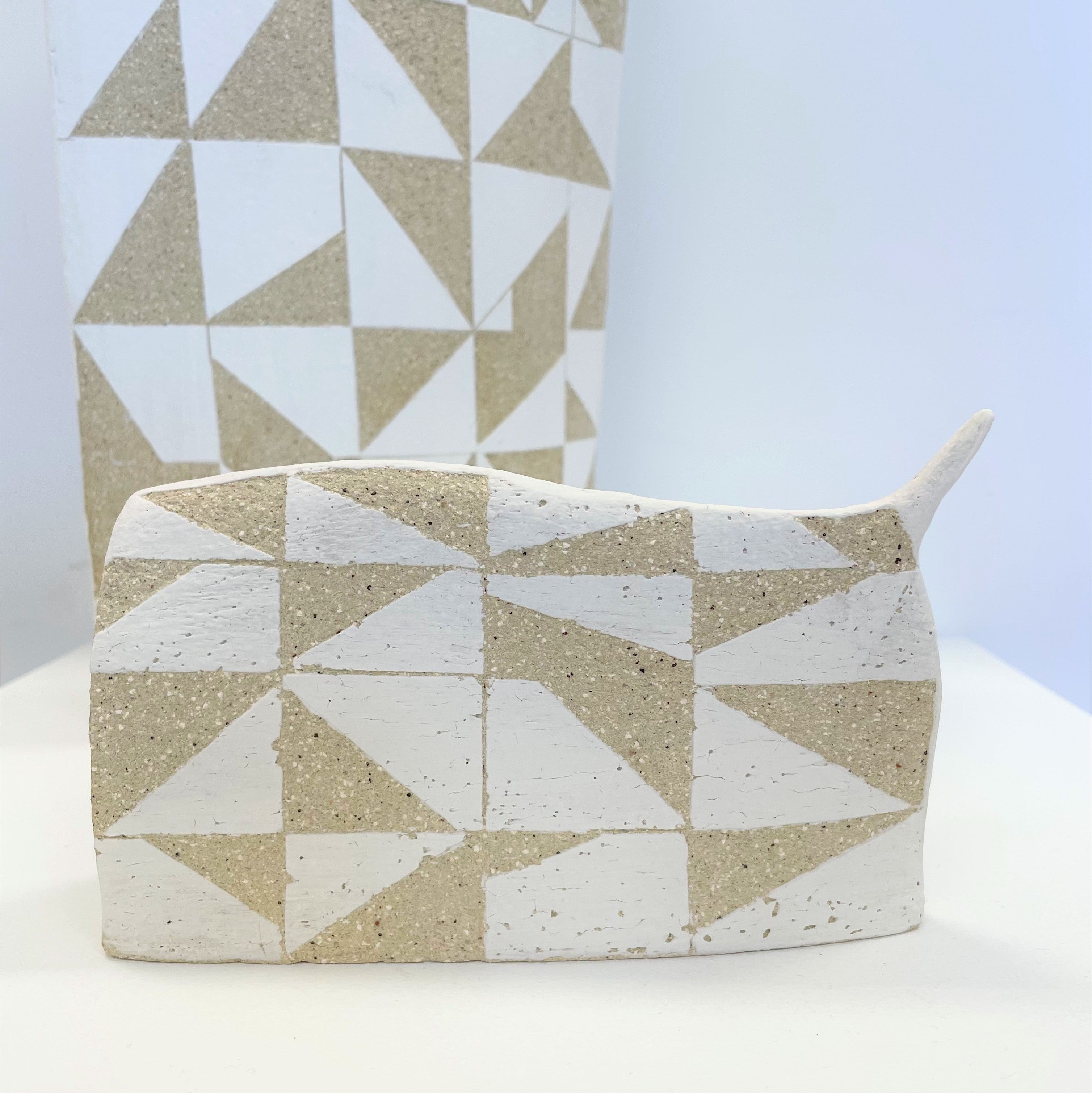 Ceramic works Tall Mountain and Small Mountain by Lynette Hirst. White geometric shapes feature over the surface of the work in white.