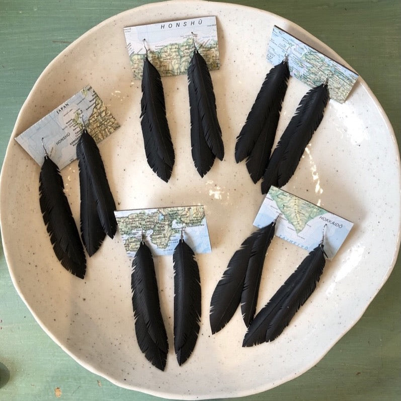 Plate of earrings with black feathers